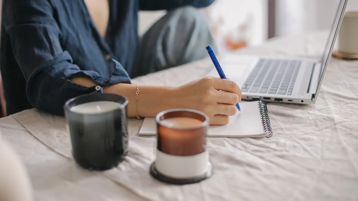A private practice owner sitting at a desk with her laptop and a notebook