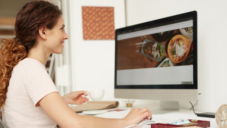 A dietitian looking at her monitor thinking of questions to ask before hiring a website designer