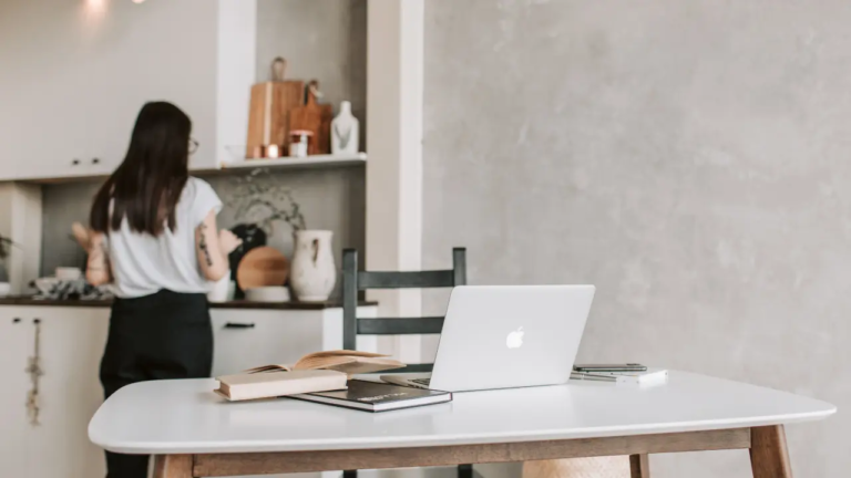 Laptop on top of a desk with books owned by a weight-inclusive provider trying to rank higher on google
