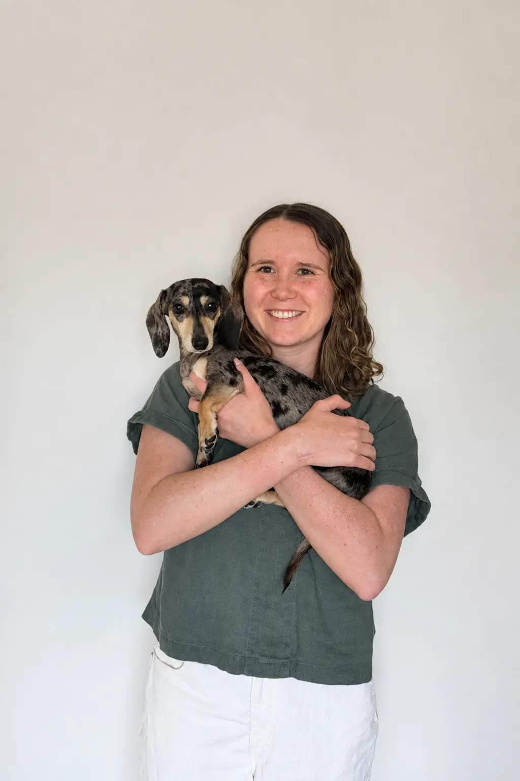 Website designer Olivia Laughman holding her dachshund puppy