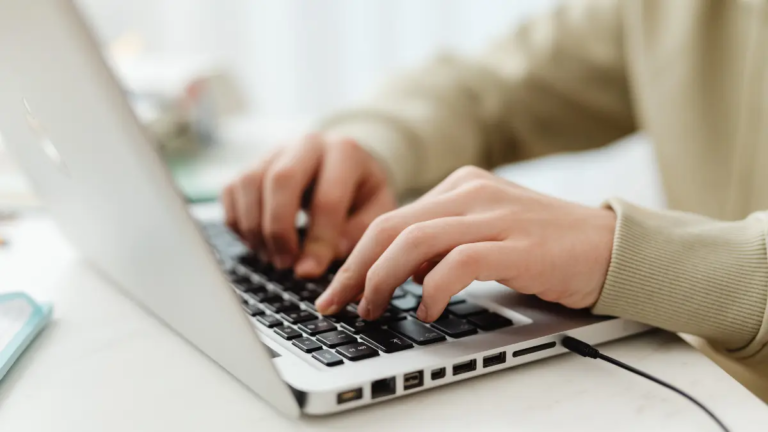 A weight-inclusive clinician working at her laptop, updating all her blogs for AEO